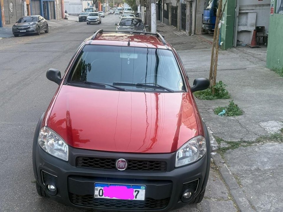 Vista frontal da Fiat Strada vermelha anunciada, estacionada na rua